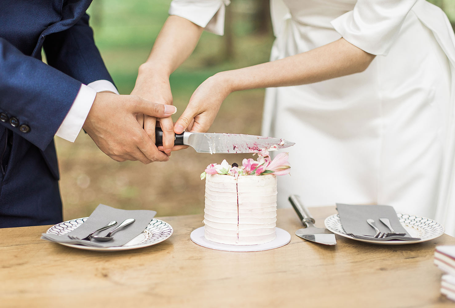 Couple cutting small wedding cake.