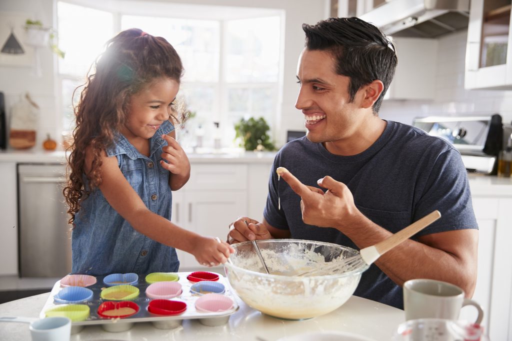 young girl and dad baking cupcakes