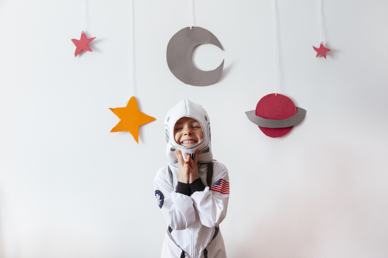girl with an astronaut costume at home