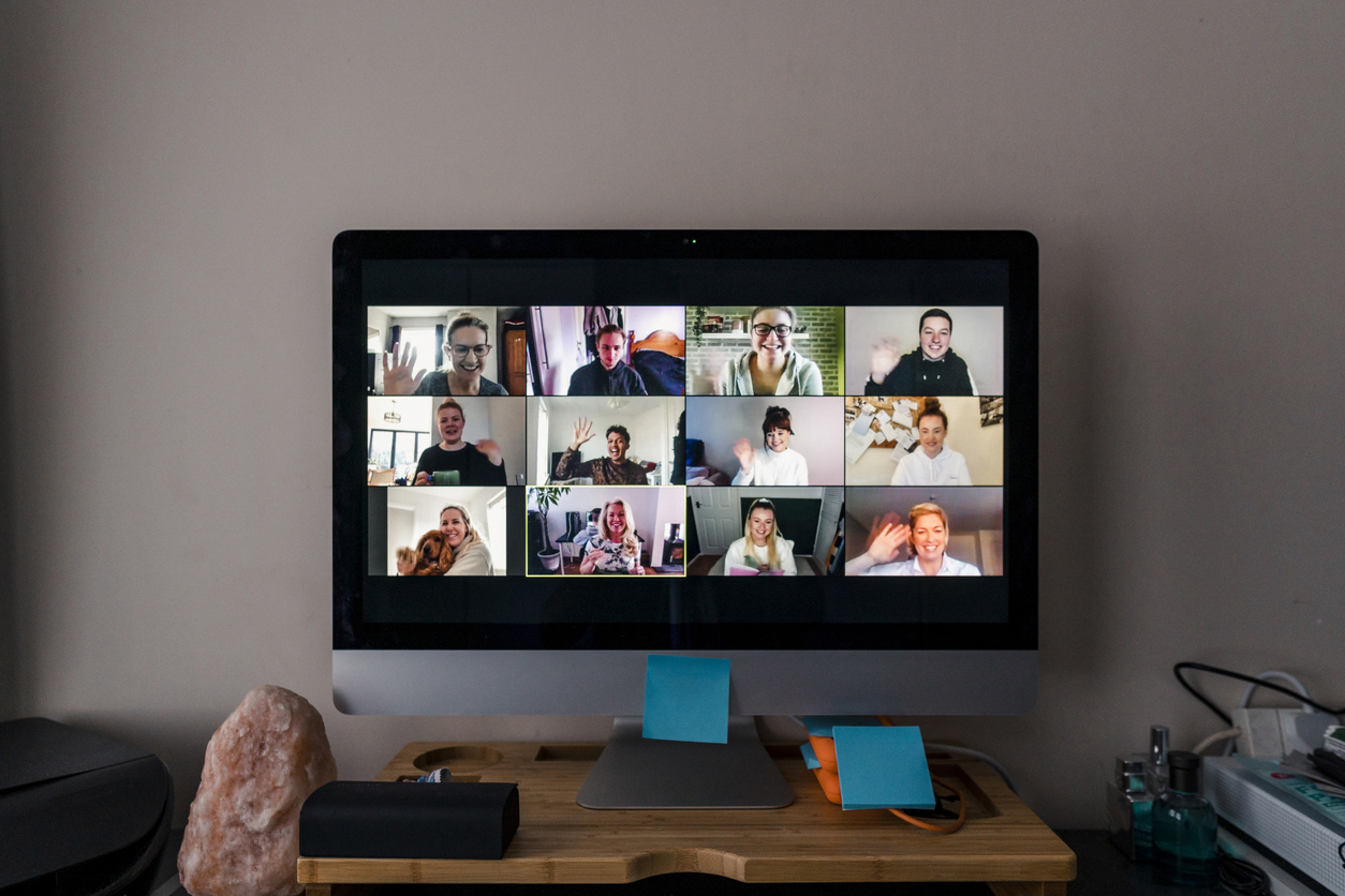 Image of a team conference call on a computer screen in a home office.