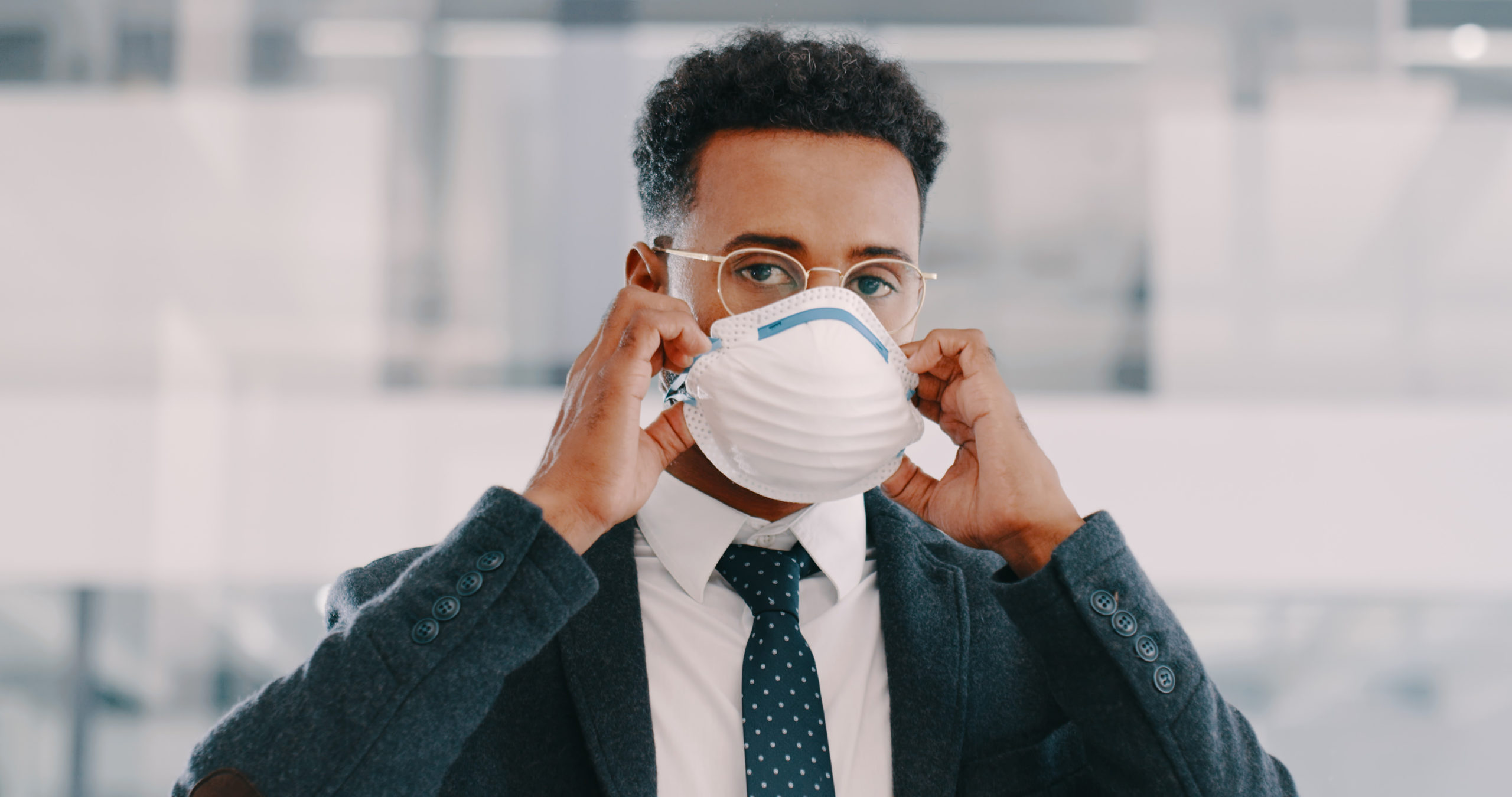 man in office taking off his protective face mask